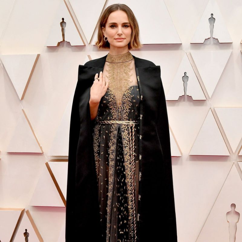 9. Natalie Portman (2020) Natalie Portman, en los Oscars de 2020, se destacó con un look que no solo fue impresionante, sino que también envió un mensaje político poderoso. La actriz lució un vestido Dior negro con bordados dorados y una capa que llevaba los nombres de las directoras que fueron ignoradas por la Academia ese año. La pieza, además de su belleza estética, representó una crítica hacia la falta de reconocimiento de las mujeres en la industria cinematográfica. Portman mostró cómo la moda puede ser una herramienta para enviar mensajes importantes, convirtiéndose en un referente de empoderamiento en la alfombra roja.